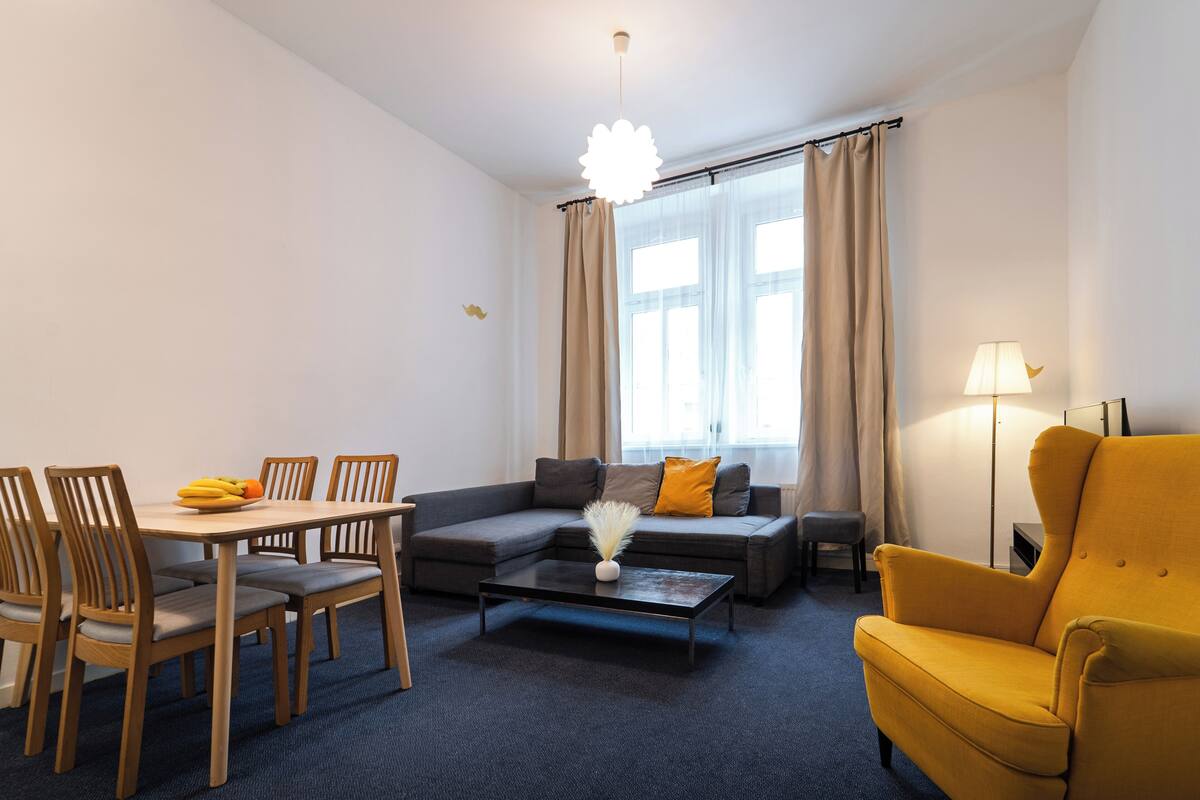 Uma sala de estar moderna com mesa de jantar, sofá e poltrona.