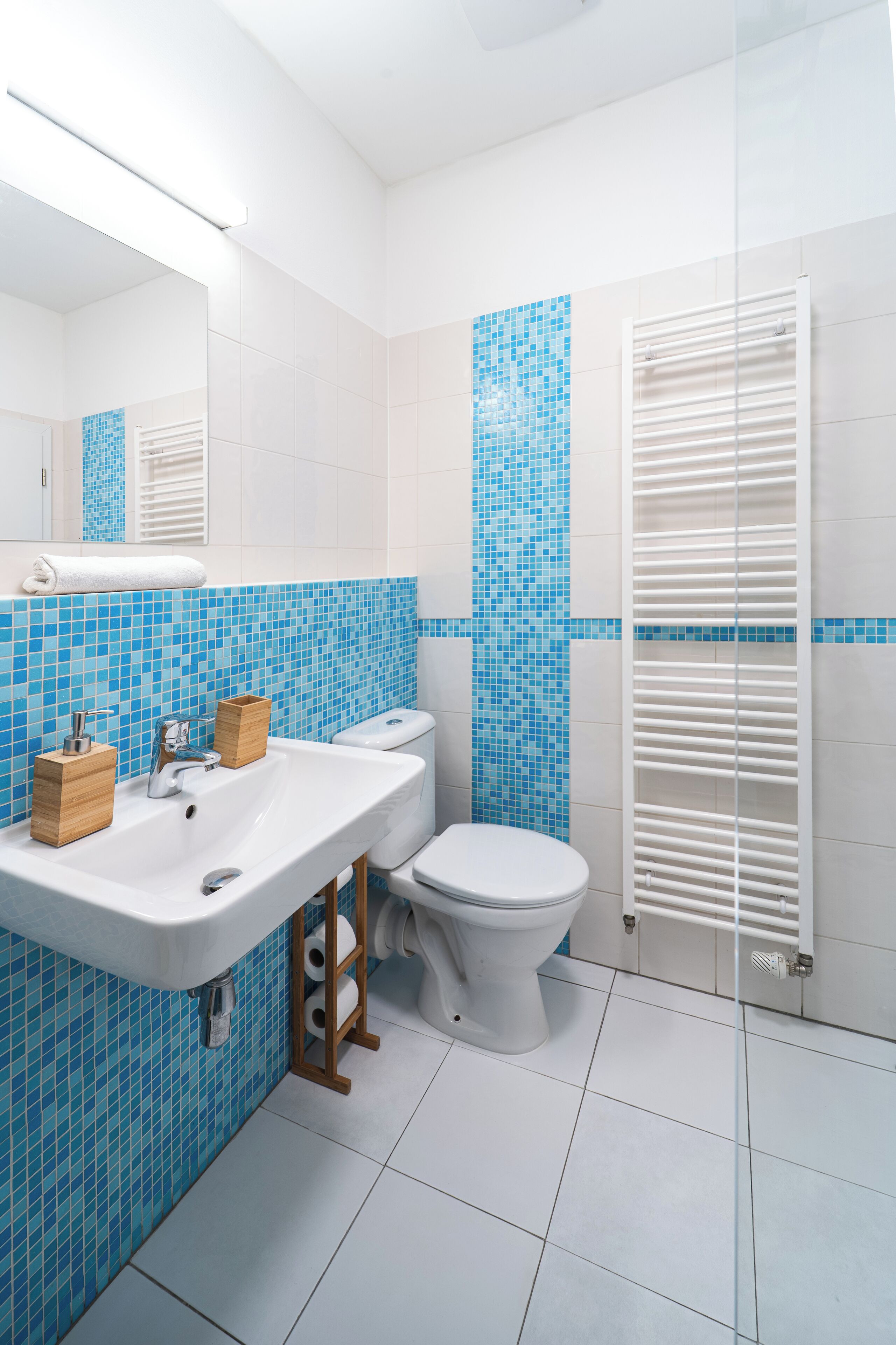 A bathroom with a white sink, a toilet, and a glass shower enclosure.