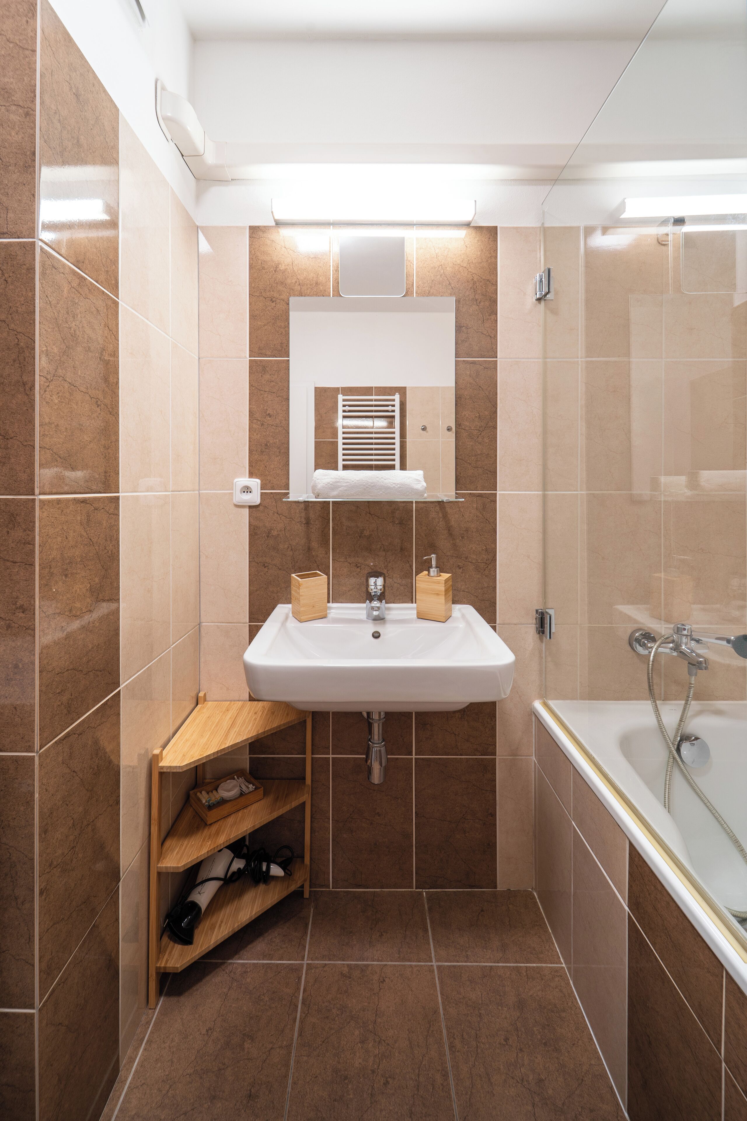 A modern bathroom with a white sink, a mirror, and a shower.