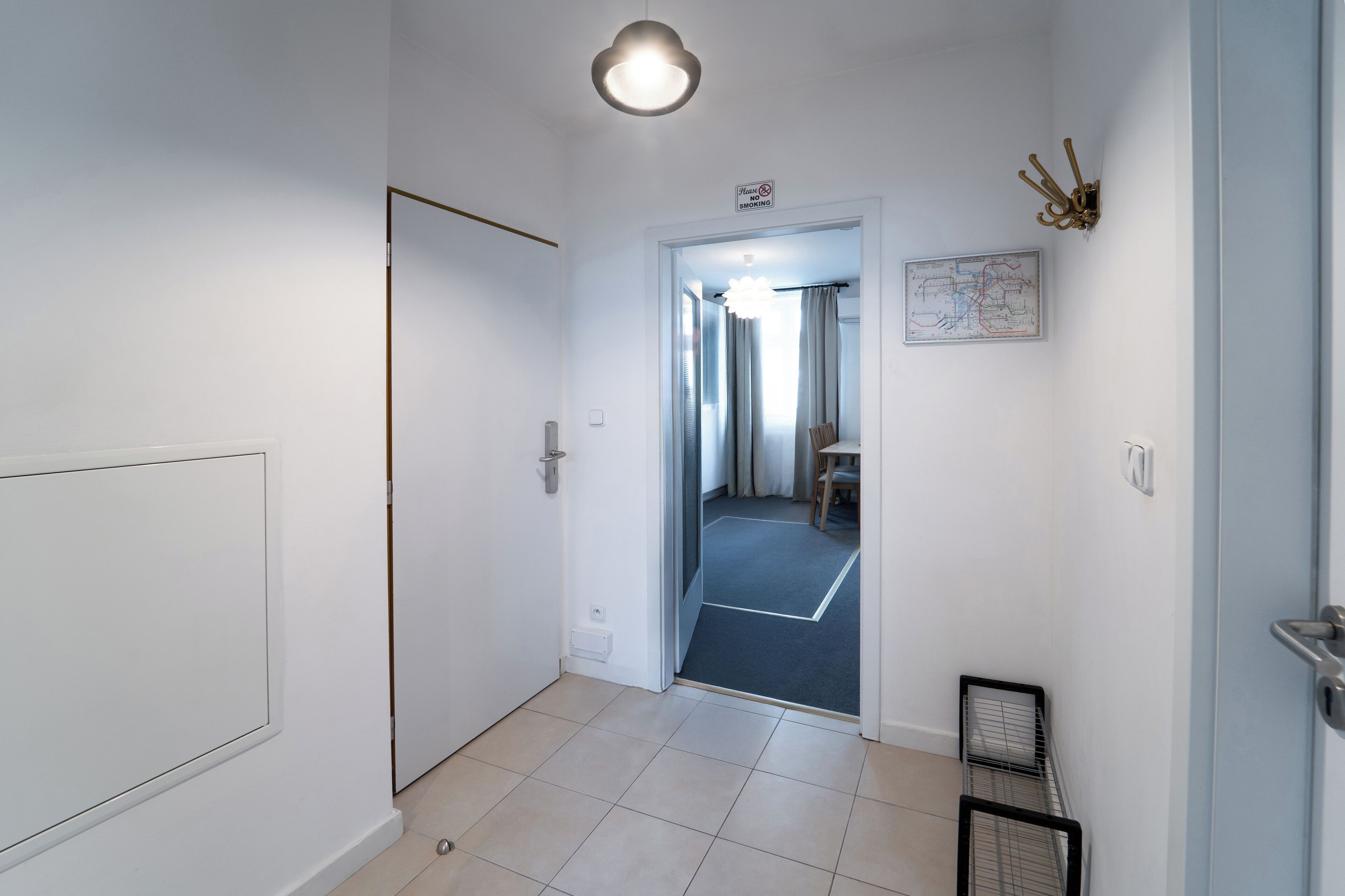 Un pasillo con una puerta que da a una habitación con una cama y un mapa en la pared.