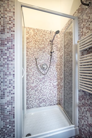 Badkamer | Een douche, een regendouche, een haardroger, handdoeken