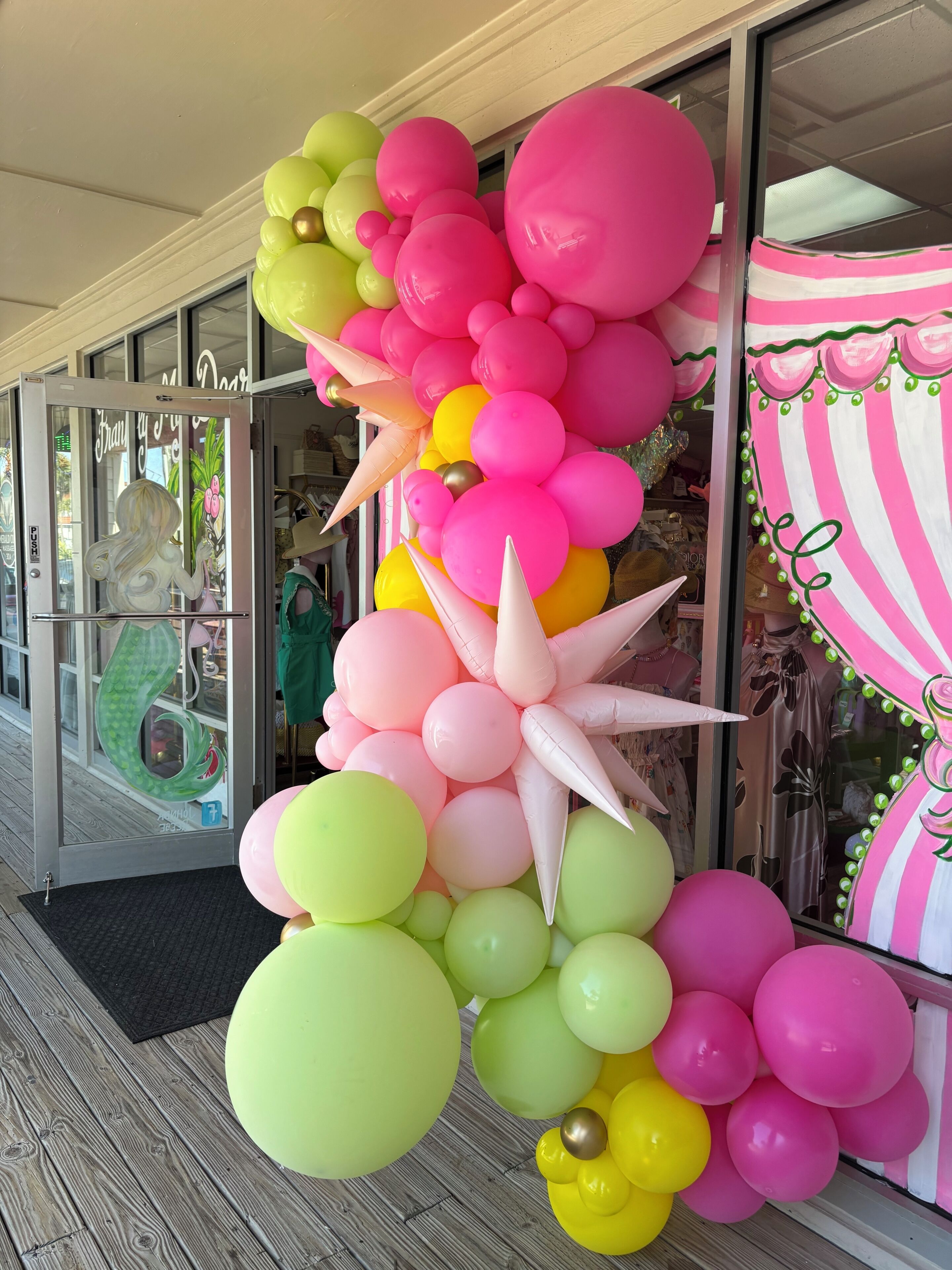 Una vetrina con un'ampia decorazione a palloncino e una porta in vetro.