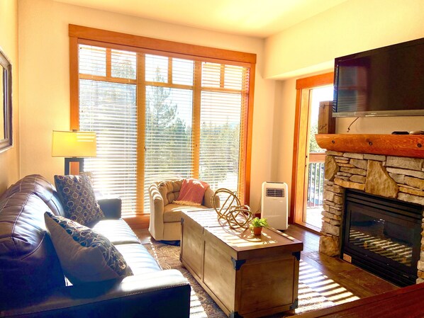 A living room with a sofa, a coffee table, and a fireplace.