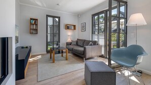 Een moderne woonkamer met een bank, een salontafel, een blauwe stoel en een tv-meubel.