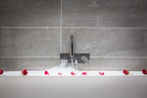 Une salle de bain moderne avec une douche et un mur recouvert de carreaux.