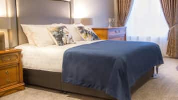 Une chambre d’hôtel avec un lit, une commode, une table de chevet et une fenêtre avec des rideaux.