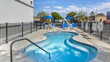 Una piscina al aire libre, sombrillas