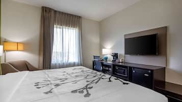 Une chambre d’hôtel avec un grand lit, un bureau avec un ordinateur, une télévision et une fenêtre avec des rideaux.