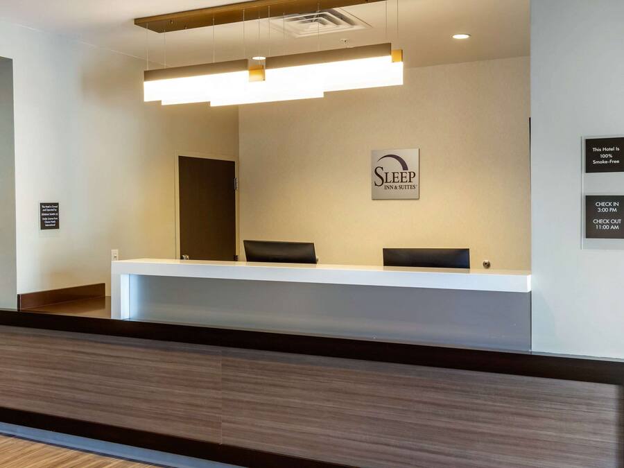A hotel reception desk with a sign indicating it is smoke-free and check-in/check-out times.