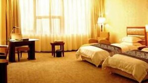 A hotel room with two beds, a desk, a chair, and a lamp. - King We Holiday Hotel (Quanzhou)