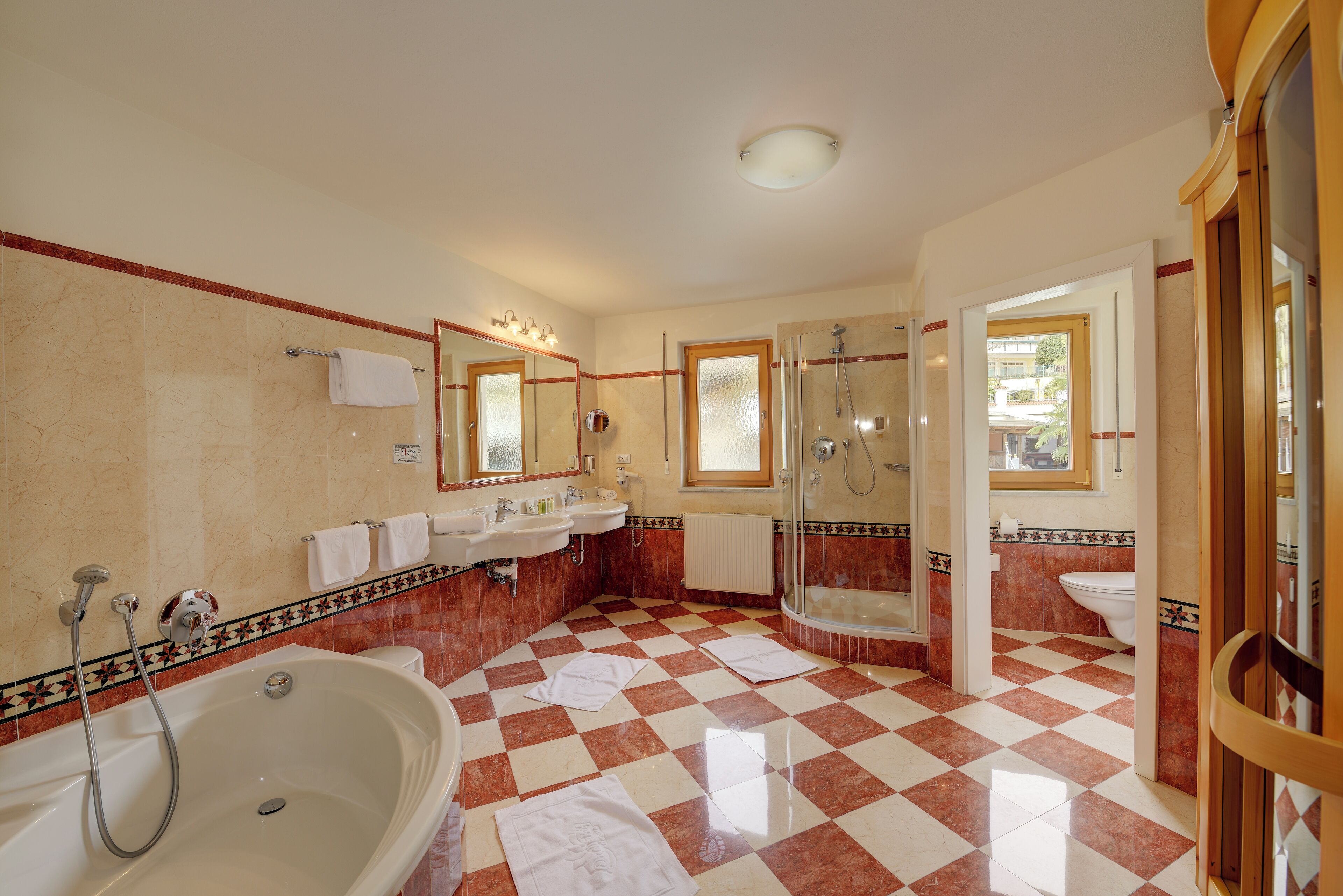 A bathroom with a checkered floor, a bathtub, a shower, and a sink.