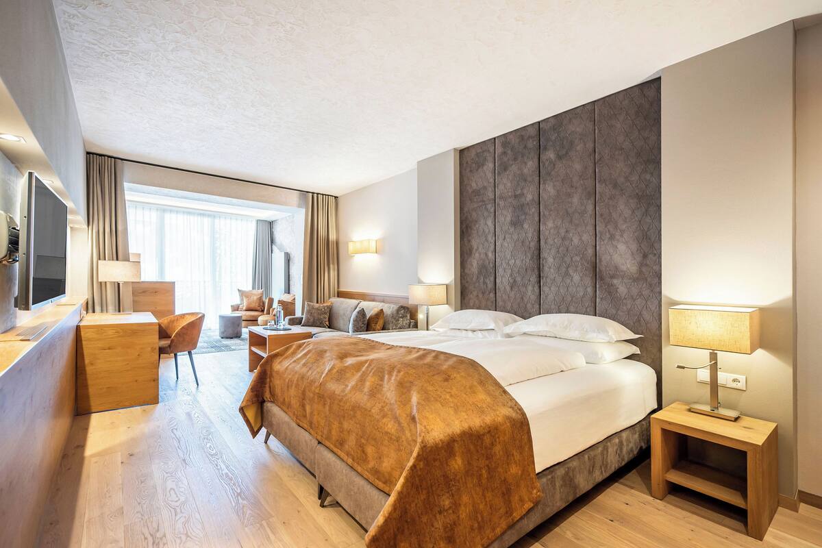 Une chambre d’hôtel moderne équipée d’un grand lit, d’un bureau, d’une chaise et d’un téléviseur.