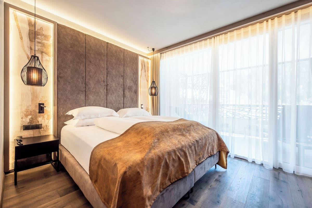 Une chambre moderne avec un grand lit, une tête de lit en bois et une table de chevet.