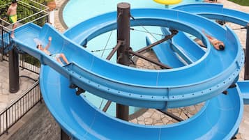 Slide into fun at our water park, featuring a multi-level water slide structure with simultaneous channels for multiple users.
