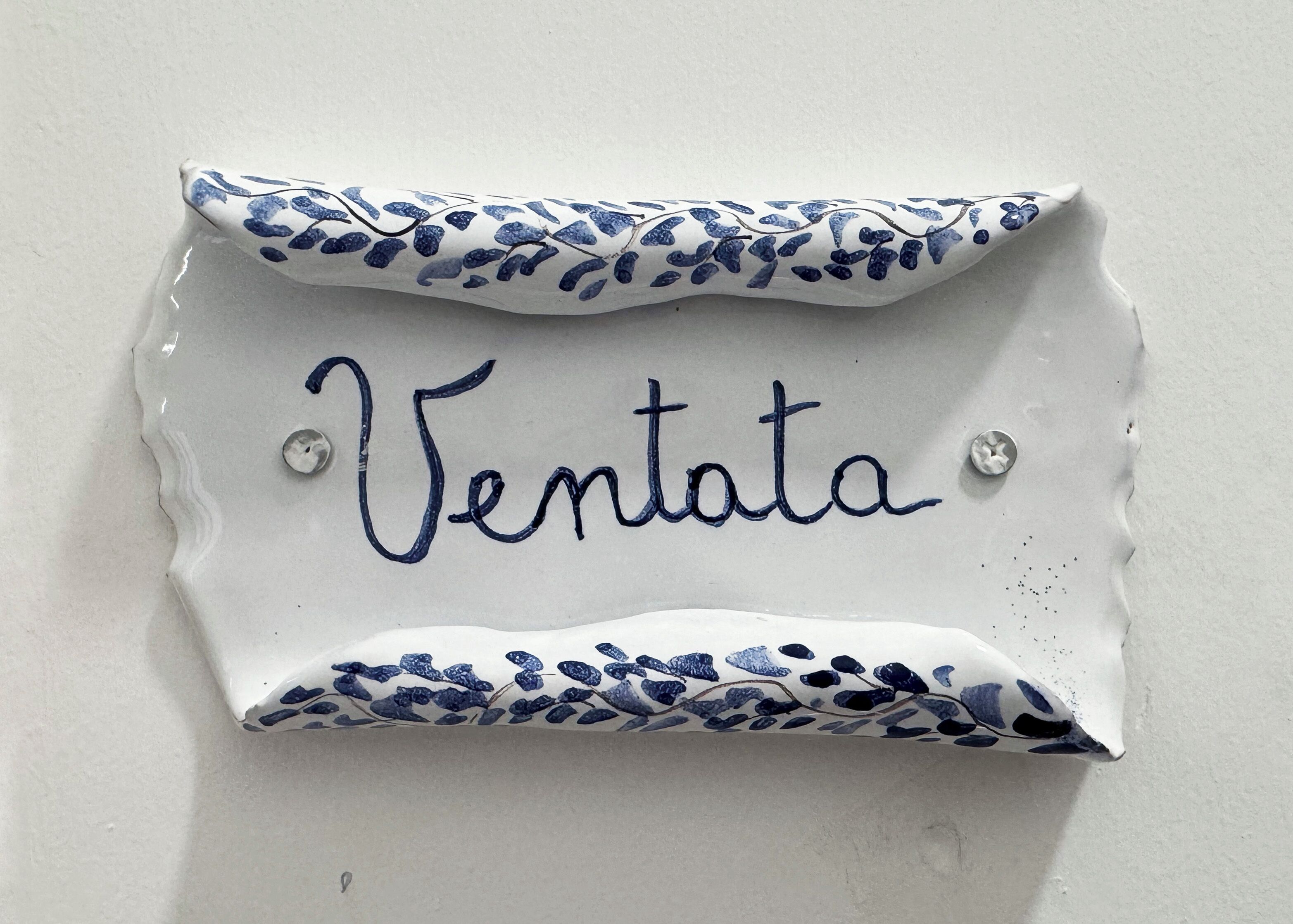 A decorative ceramic plaque with the word "Ventata" written on it.
