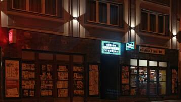 A building with multiple signs, including one for 'DESIGN APARTMENT VYSOCHINA' and another for 'PARTNER BOMBULE'.