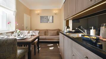 Una cocina moderna con armarios de madera, encimera negra y un área de comedor con sofá y sillas.