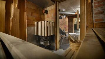 A narrow, rustic room with exposed brick walls, a radiator, and a wooden bench.