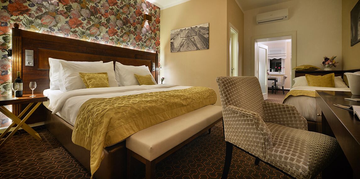 Une chambre d’hôtel avec un grand lit, une chaise, un bureau et une fenêtre.