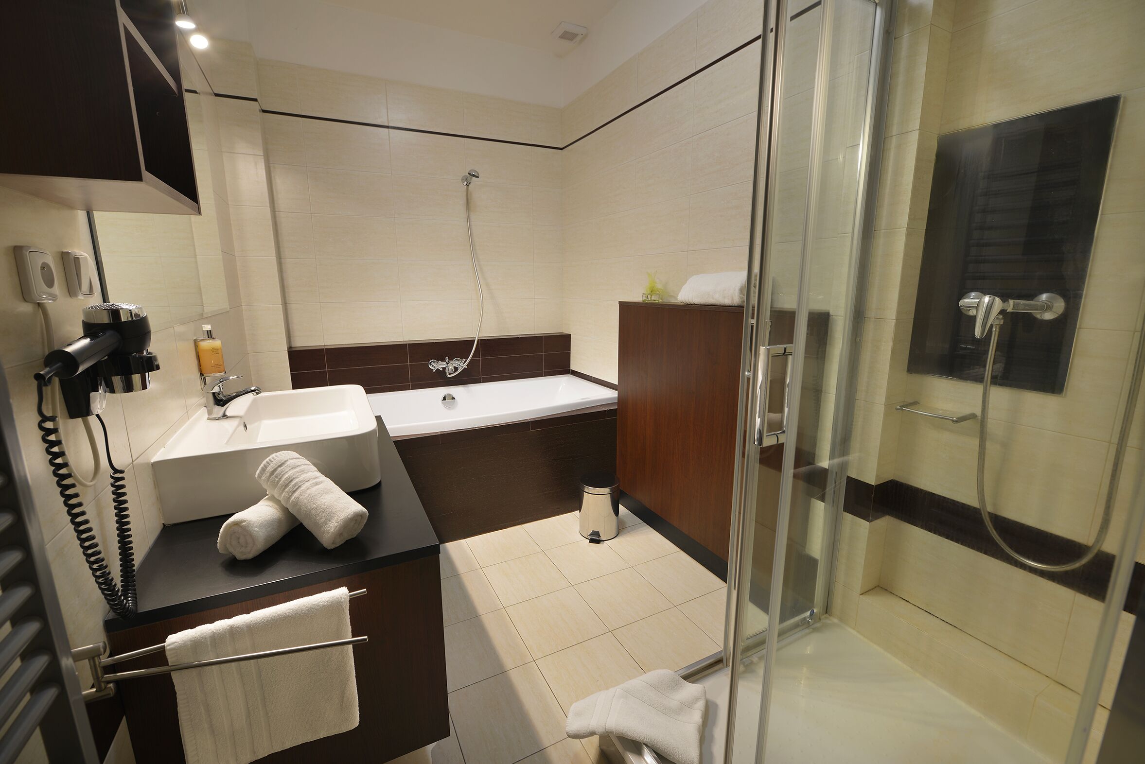 A modern bathroom with a glass-enclosed shower, a sink with a mirror, and a towel rack.