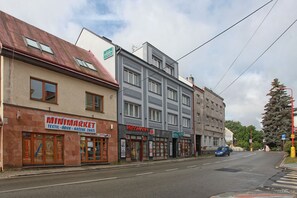 A street view with buildings including a 'Minimarket' and a 'Rossmann' store. - Vysocina Design Apartments (Hlinsko)