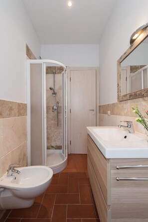 Apartamento básico, 1 habitación | Baño | Ducha, cabezal de ducha tipo lluvia, secador de pelo y bidé