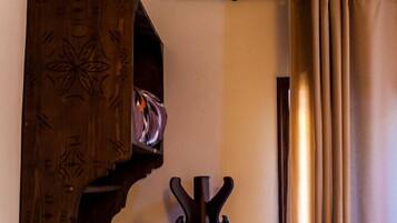 Techo de madera con vigas a la vista, un perchero y un estante de pared con un diseño decorativo.