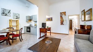A spacious living area with a dining table, sofa, and kitchen in the background. - Flospirit - Bellini (Florence)
