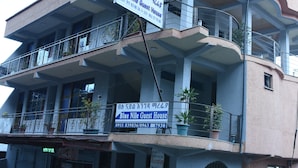 Un edificio de varios pisos con balcones, un letrero que dice 'Blue Nile Guest House' y asientos al aire libre.
