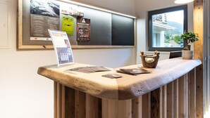 A reception desk with a bulletin board, a window with a view, and a potted plant.