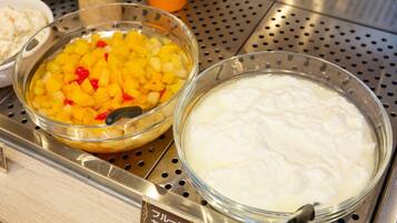 Un buffet avec deux bols de nourriture : l’un contenant des dés de mangue et l’autre une substance crémeuse et blanche.