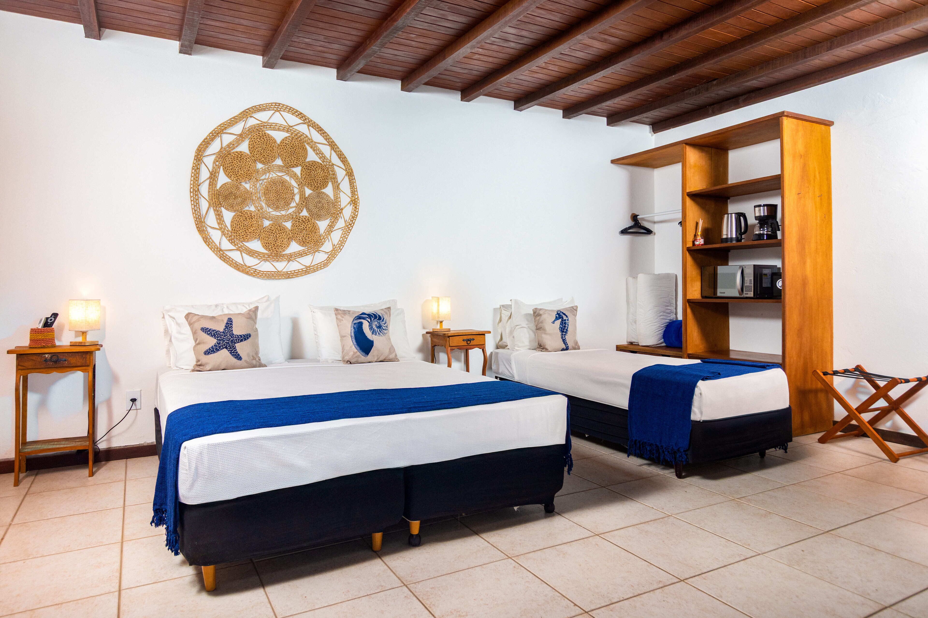 Habitación de hotel con dos camas, un aparador de madera y un adorno en la pared.