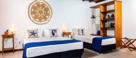 Habitación de hotel con dos camas, un aparador de madera y un adorno en la pared.