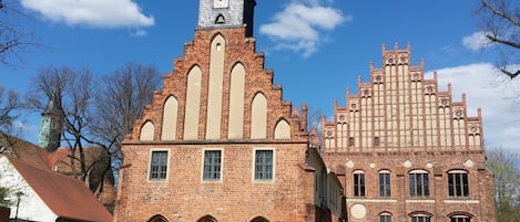 A historic building with a clock tower and arched windows, featuring a mix of brick and stone construction.