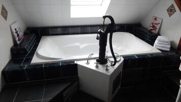 A modern bathroom with a freestanding bathtub, a shower, and a vanity with a sink.
