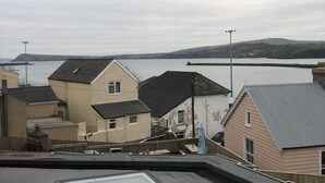 A residential area with houses, a view of a body of water, and a cloudy sky.