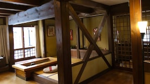 Et traditionelt japansk rum med tatamimåtter, træbjælkeloft og en skydedør.
