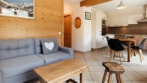 Ein modernes Wohnzimmer mit einer Couch, einem Couchtisch und einem Essbereich mit Stühlen und einem Tisch.