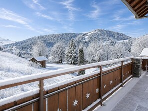 A wooden balcony with snow-covered railings overlooking a snowy mountainous landscape. - 3 Rooms with WiFi and Parking, Near Slopes, Sunny (La Clusaz)