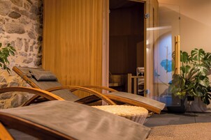 Una habitación con pared de piedra, muebles de madera y una planta en maceta.