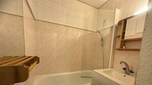 A bathroom with a bathtub, a sink, and a mirror. - 2-room apt for 5 in station center with balcony and pool (Plagne Bellecôte)