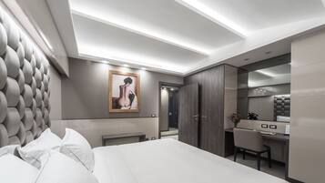Una habitación de hotel moderna con una cama grande, un escritorio y un armario.