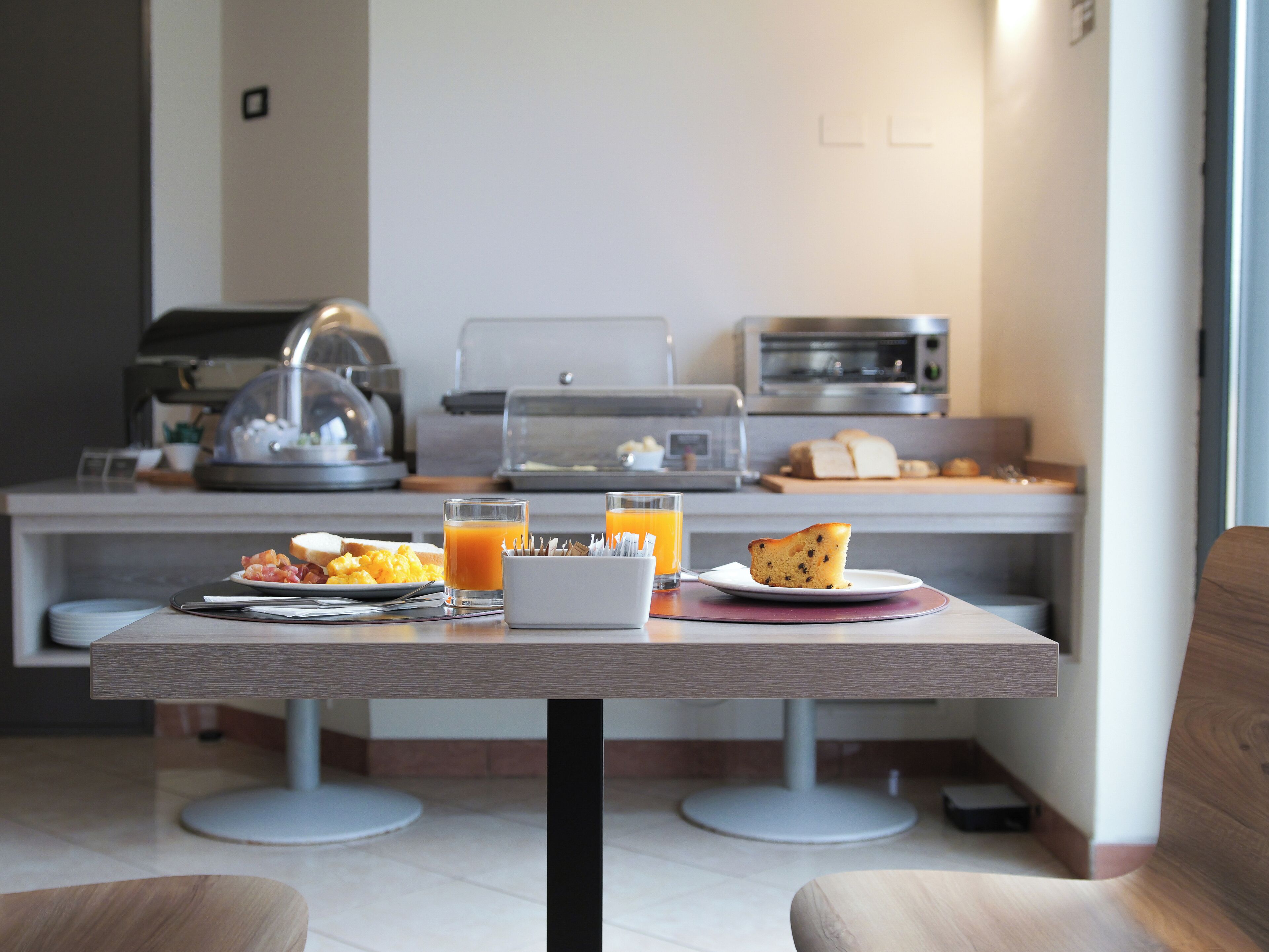 Une table dressée pour le petit-déjeuner, avec des aliments et une machine à café.