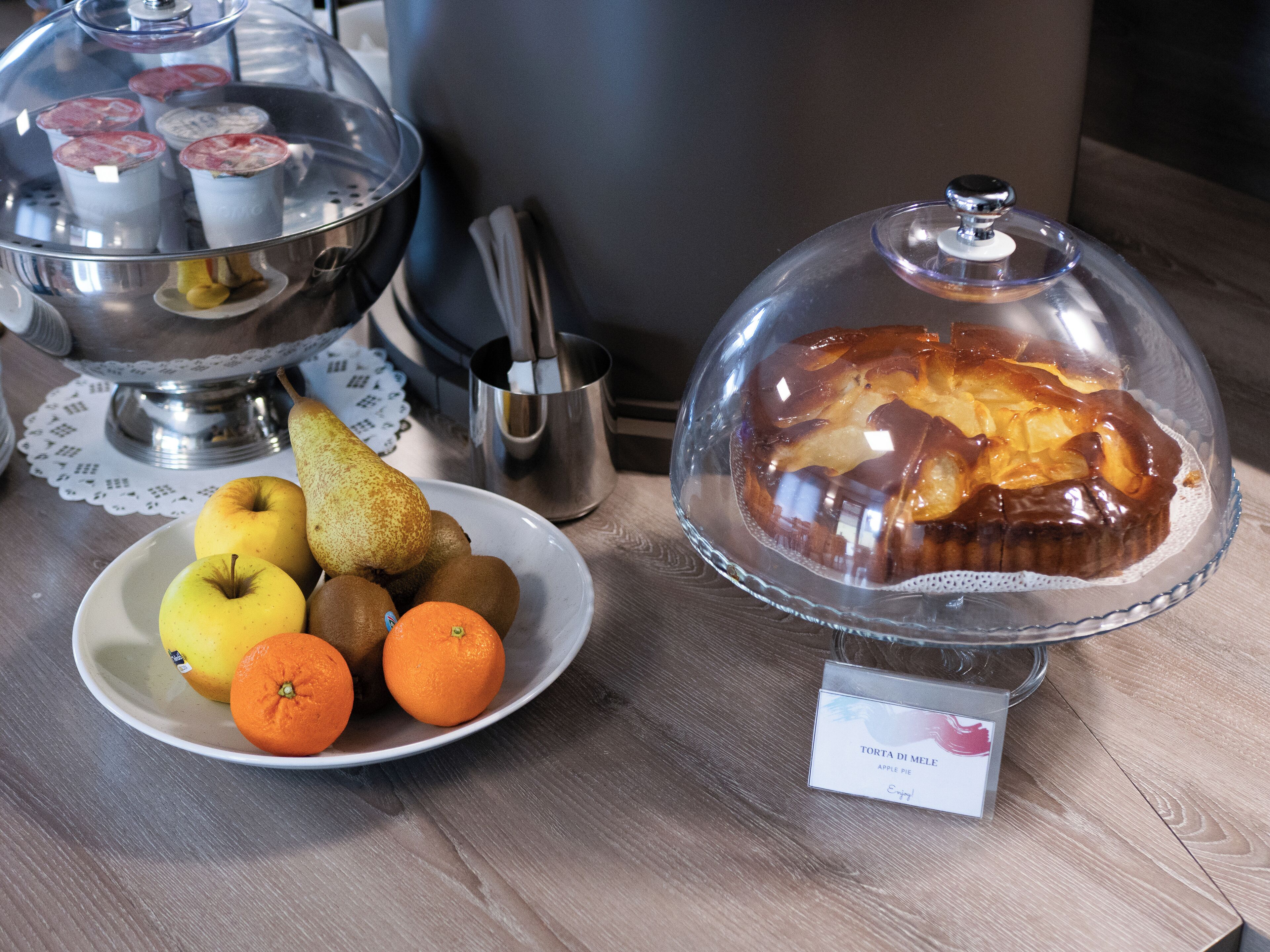 Une présentation de desserts comprenant une tarte recouverte et une assiette de fruits.