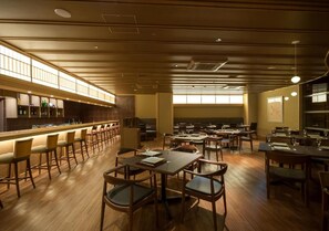 A restaurant with a long counter, multiple tables, and chairs. - Saka Hotel Kyoto (Kyoto)
