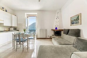 Un espacio habitable compacto con kitchenette, comedor, sofá y vista al mar.