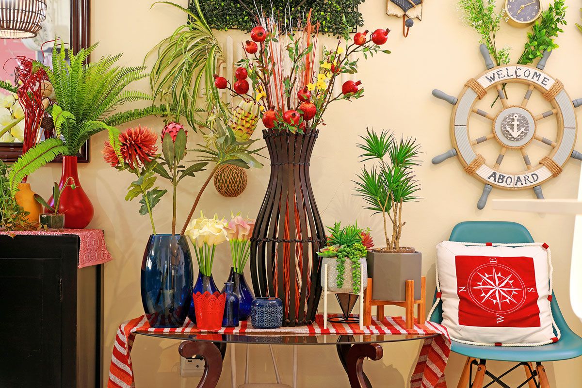 A table with various potted plants and a decorative sign saying "WELCOME ABOARD".