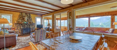 Cozy retreat with a stone fireplace, comfortable seating area, and large windows offering views of the surrounding landscape.