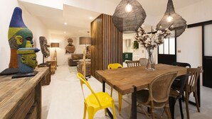 A modern dining area with a wooden table, wicker chairs, and pendant lights. - Out of Africa, 4BR/3BA, 8 people (París)