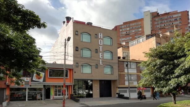 Un hotel amb una façana moderna, moltes finestres i un terrat pla.